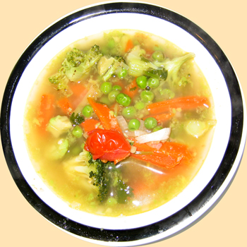 A bowl of clear soup with avocado